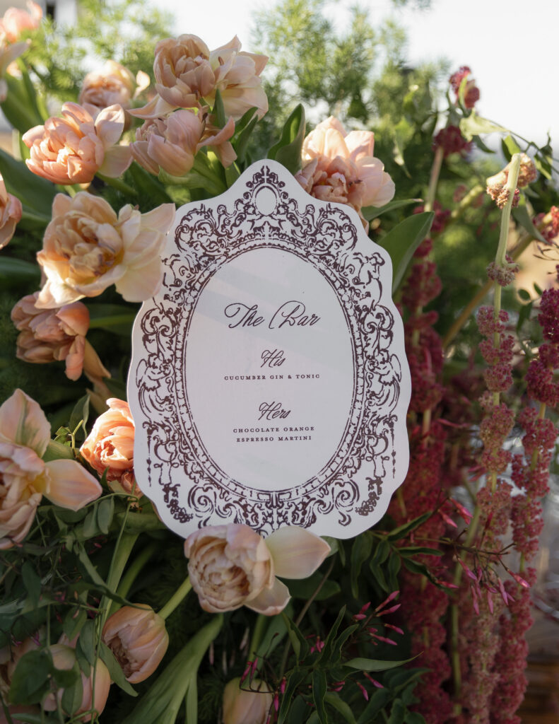 Custom die-cut wedding bar menu surrounded by burgundy and blush florals