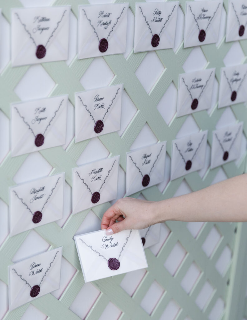 Wedding guest selecting their name card from a custom lattice seating chart at Hempstead House